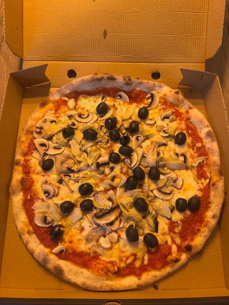 Freshly baked wood-fired pizza topped with olives and mushrooms in an Olivetta Pizzeria box